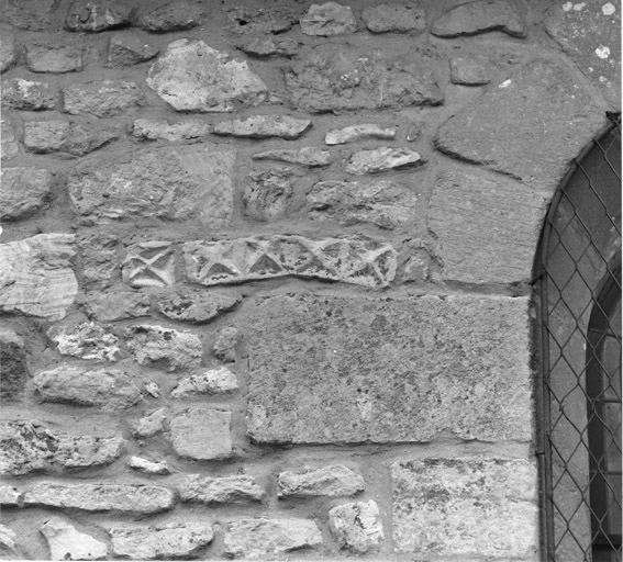 Détail d'une pierre sculptée remployée dans le mur sud de la nef.