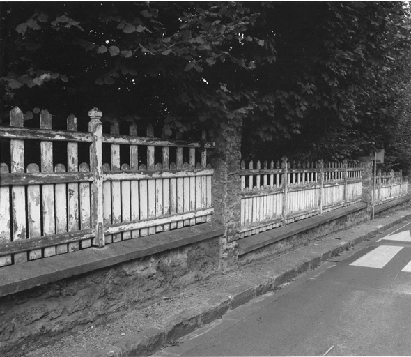 Vue d'une clôture de bois en bordure de rue.