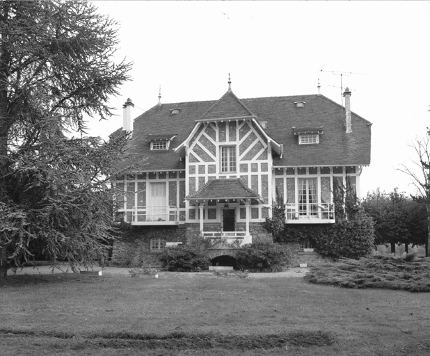 Vue de la façade antérieure d'une maison située en milieu de parcelle.