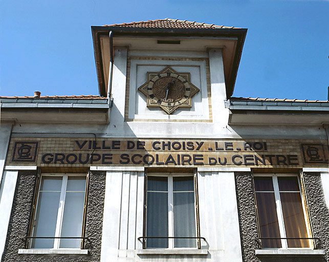 Détail de l'élévation antérieure des écoles primaires : l'horloge en céramique.