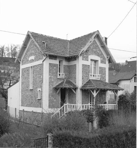 Vue de la façade antérieure d'une maison située en milieu de parcelle.