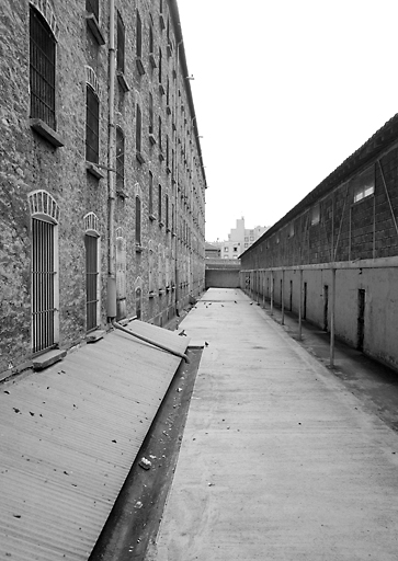 Le groupe central : à gauche, un bâtiment de détention cellulaire, à droite, l'entrée des cours de promenade.