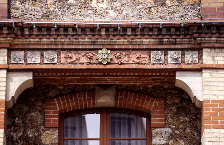 Détail du décor en terre cuite et en céramique situé au-dessus du balcon du maire.