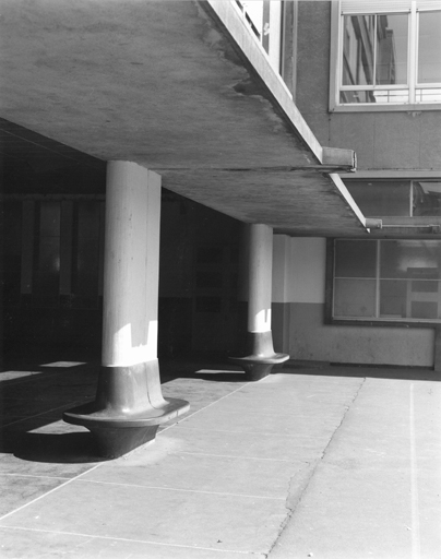 Vue des piliers de la cour avec des bancs en granit noir.
