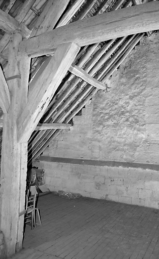 Vue partielle de l'intérieur de la grange montrant l'appareillage du mur auquel elle est adossée à l'est.