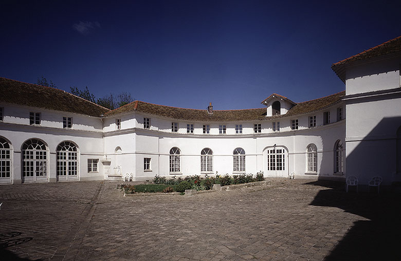 Vue des écuries sur la cour. Au centre, l'ancien bain des chevaux transformé en parterre.