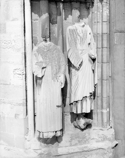 Détail des statues de l'ébrasement de gauche : à droite, saint Jean tenant un livre, à gauche, un ecclésiastique.