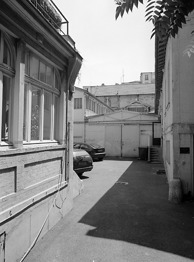 Vue depuis l'entrée à gauche les bureaux au fond les anciens ateliers parasités par des constructions neuves.