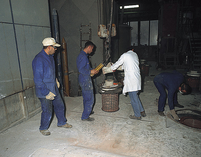 Coulée de bronze : déplacement du moule de potée vers la fosse.