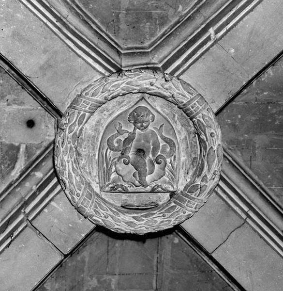 Clef de voûte de la chapelle des fonts baptismaux : un putto encadré de deux dauphins.