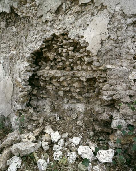 Détail de l'élévation d'un mur : vue des moëllons, de la terre et des chaînes de plâtre.