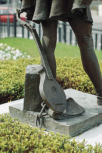 Statue de François Villon : détail de l'instrument à cordes de la famille du luth.