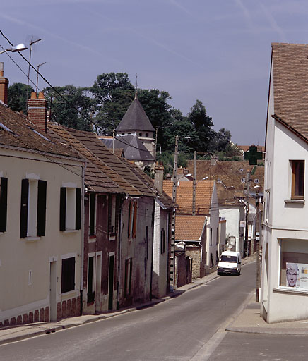 Vue d'ensemble de la rue et d'un alignement de maisons 'élémentaires'.