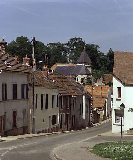 Vue d'ensemble de la rue et d'un alignement de maisons 'élémentaires'.