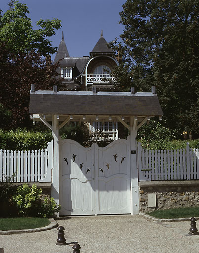 Vue d'ensemble du portail en bois protégé par un auvent de tuiles.