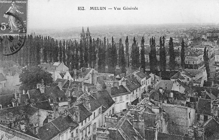 'Vue générale' de Melun, depuis le nord (cliché sans doute pris depuis l'église Saint-Aspais). Au centre, la rue Saint-Aspais. Au second plan, le rideau de peupliers bordant le petit bras de la Seine. Plus au fond, l'île Saint-Etienne et la rive sud. On distingue la façade du manège de cavalerie.