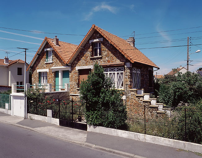 Vue d'ensemble : un escalier dont le mur d'échiffre est placé dans le prolongement de la façade donne accès au rez-de-chaussée fortement surélevé.