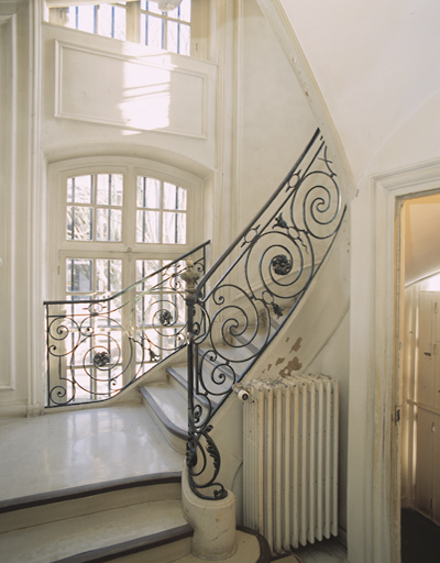 Départ de l'escalier situé à l'extrémité du vestibule (côté gauche). Rampe en ferronnerie de style Louis XVI.