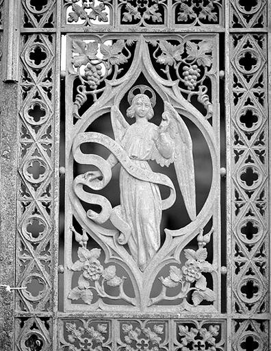 Détail de la grille en fonte de la chapelle : ange du vantail droit.