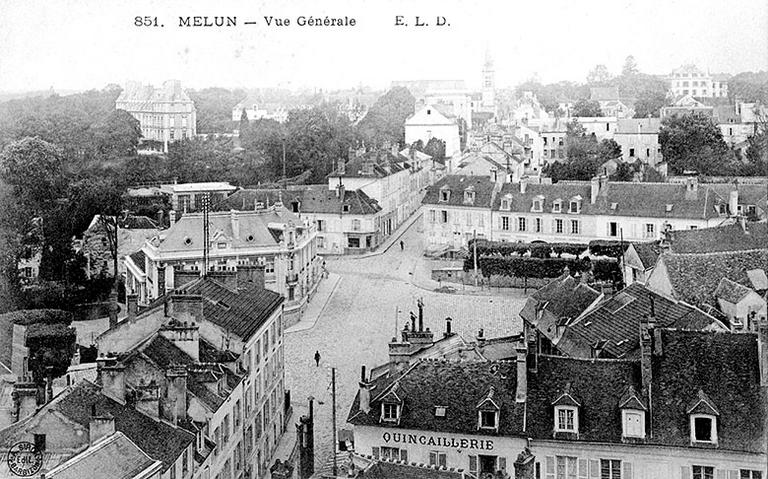 Panorama pris depuis le clocher de Saint-Aspais : la place de la Porte de Paris et la colline Saint-Barthélemy, vers 1908. Au fond se profilent : à gauche, la préfecture ; au centre, le clocher de Saint-Barthélemy ; à droite, la villa Despatys. Au premier plan : les toits des maisons de la rue Carnot et de la rue du Miroir.