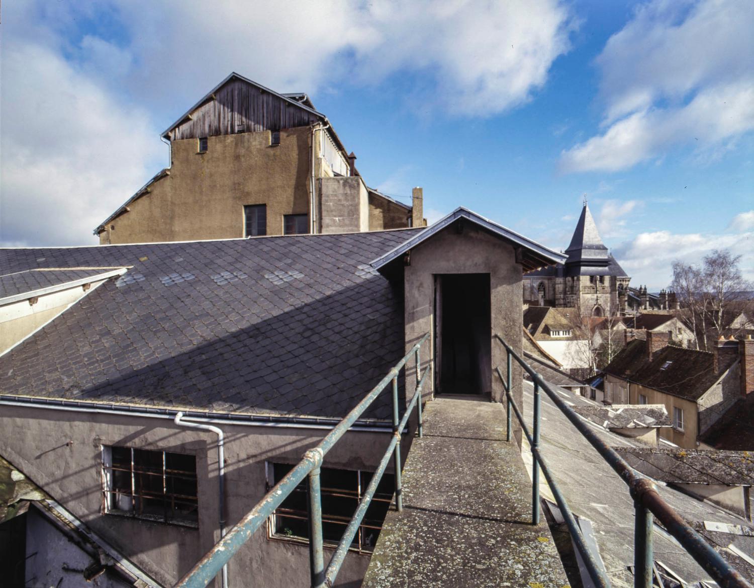 Vue des toitures vers le bâtiment principal, depuis la passerelle conduisant à la grande citerne.