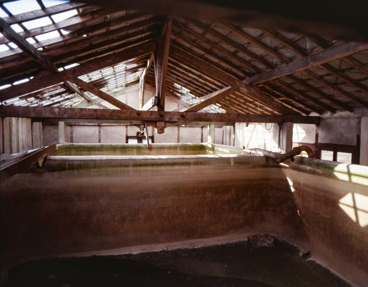 Intérieur du bâtiment de la citerne. L'eau pompée dans le ru de l'Opton (installations à côté de la maison du gardien du Moulin brûlé), servait à refroidir l'activité d'extraction végétale. L'eau chaude ne pouvant pas être directement rejetée dans la rivière, elle était stokée dans ce réservoir. L'hiver, après refroidissement durant la nuit, l'eau pouvait de nouveau être réuilisée au refroidissement, sans pompage inutile.