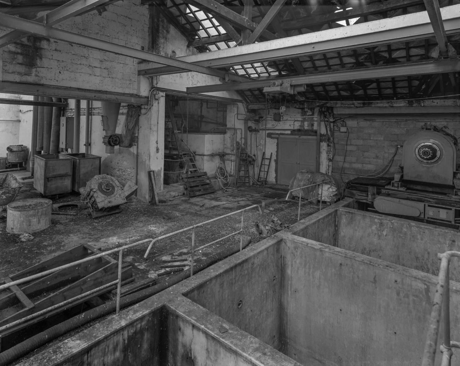 Bâtiment C. Grandes cuves de béton, construites vers 1950, permettant une première étape de macération acide ou alcaline des plantes.