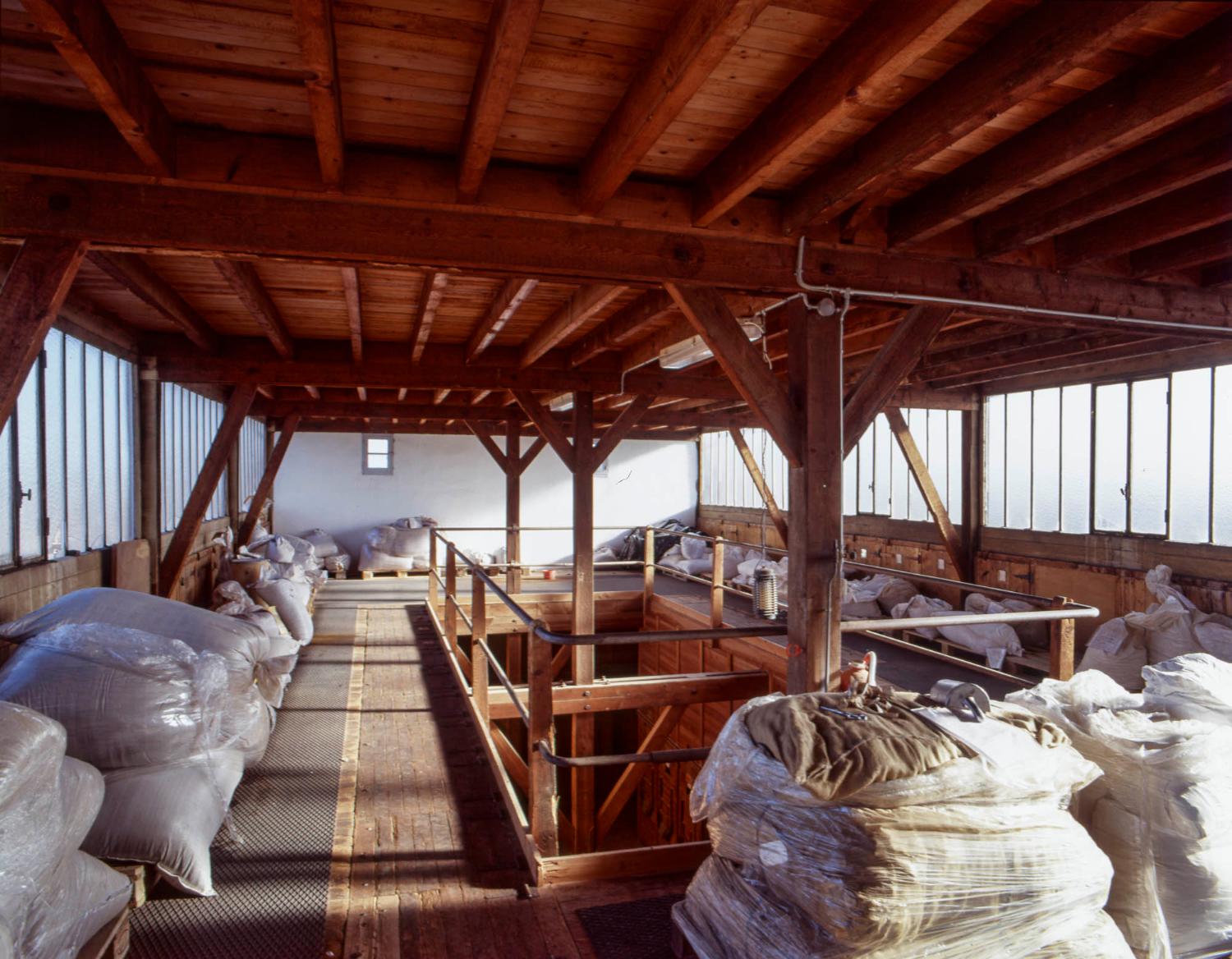 5ème étage ou mezzanine du bâtiment principal. Lieu de stockage (avant les sacs de plantes) de wagonnets contenant les plantes coupées et accès aux trappes permettant de remplir les silos.
