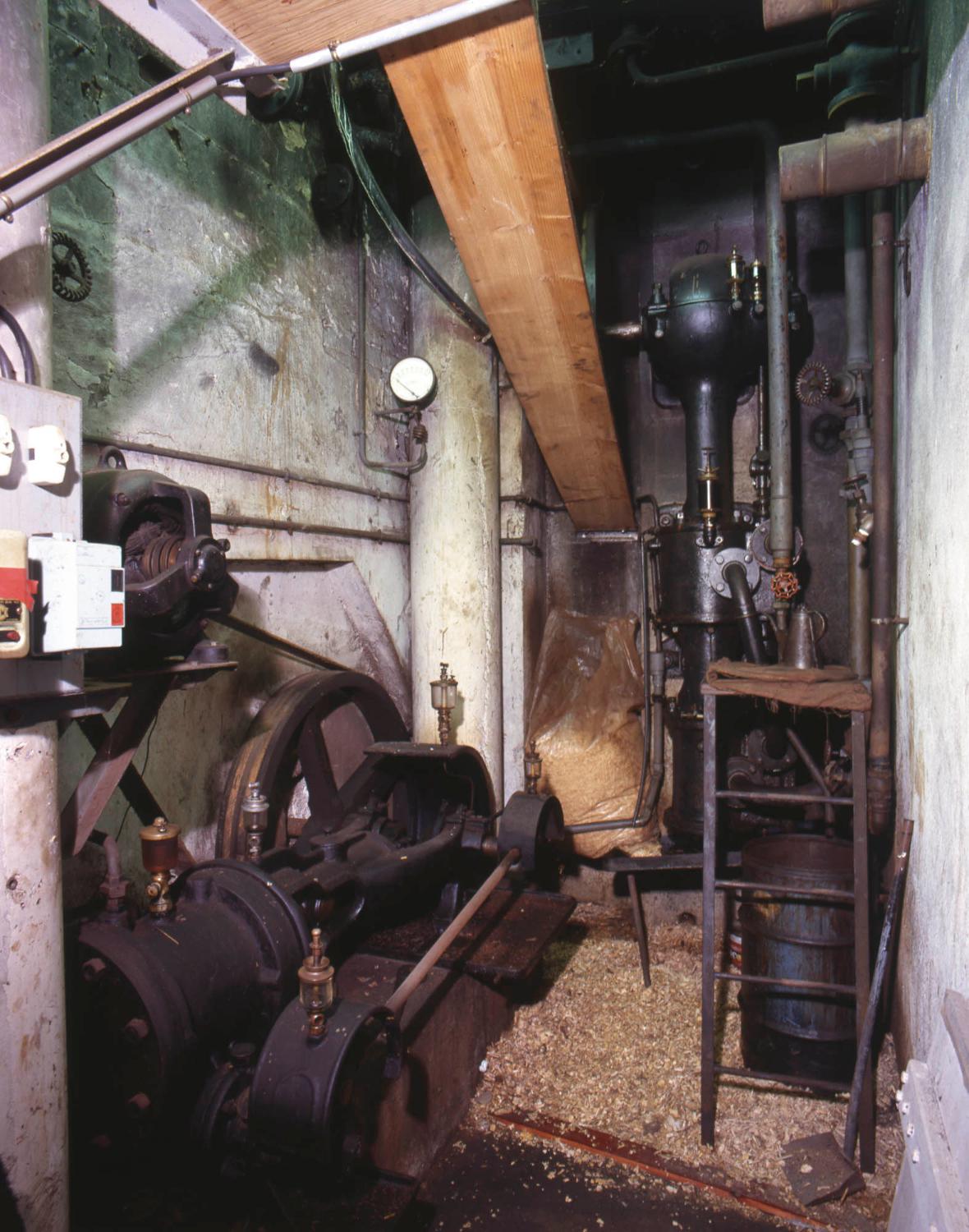 Bâtiment A (à l'angle des bâtiment G et H). A gauche, un compresseur et au fond, une pompe à vide, utilisés pour l'extraction végétale. Le vide permettait d'évaporer les solvants sans chauffer beaucoup, protégeant ainsi les principes actifs des plantes.