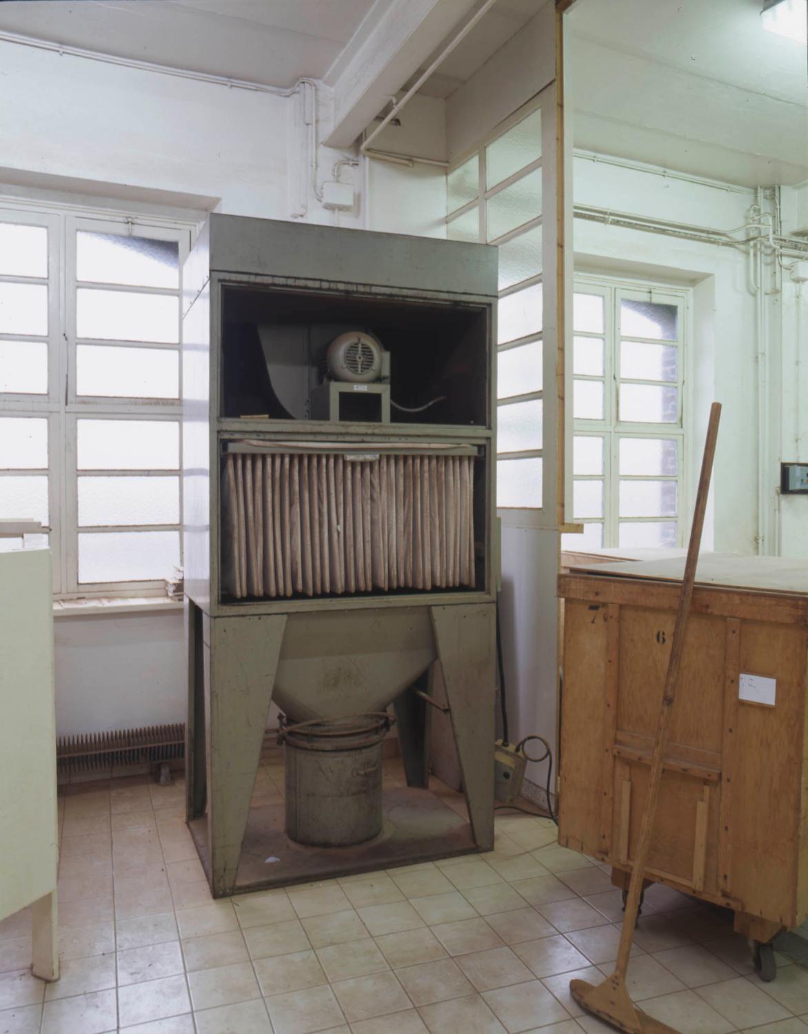 Filtre à poussière (non raccordé) placé au 2e étage du bâtiment principal. L'aspiration se réalisait de bas vers le haut.