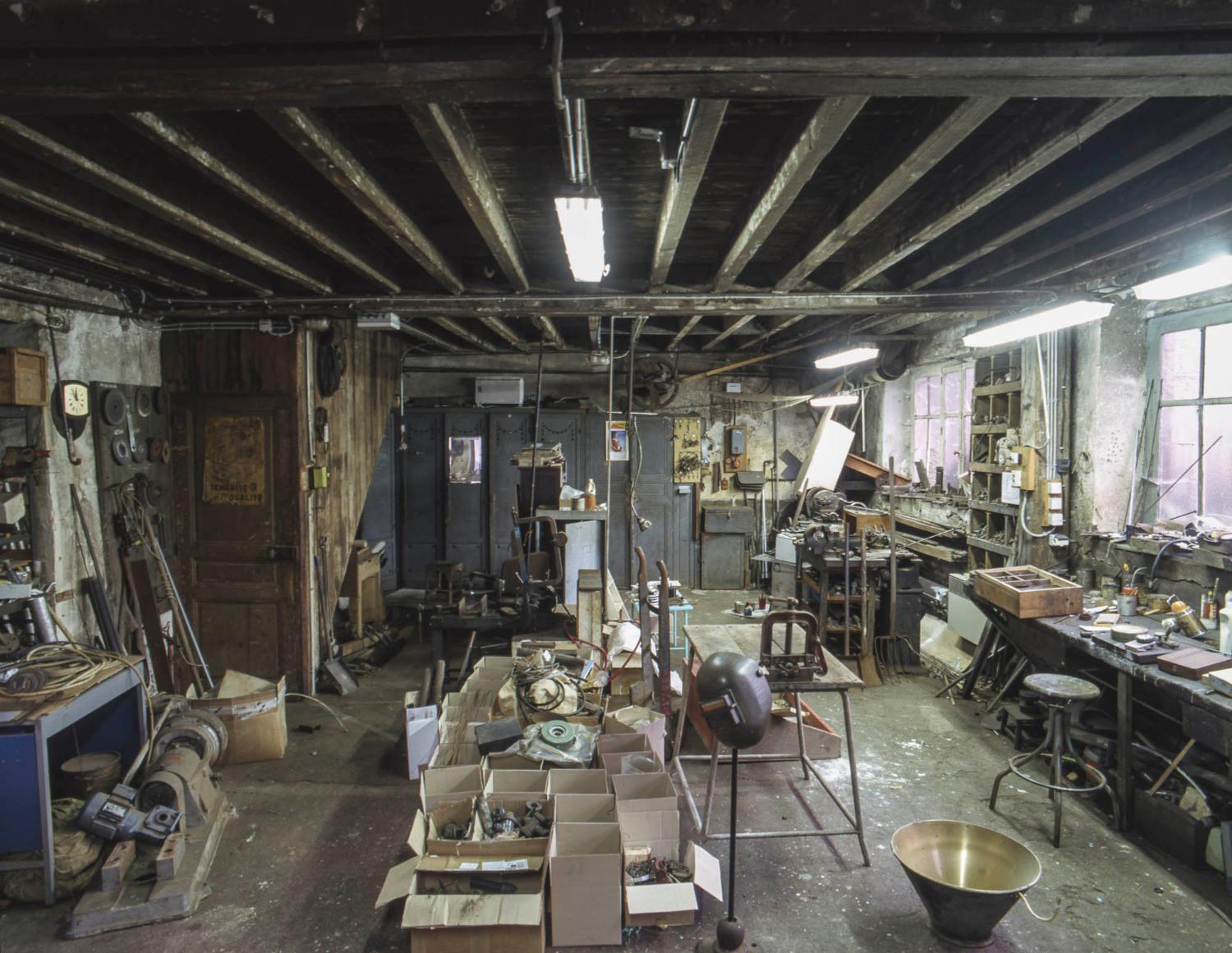 Bâtiment J, atelier de mécanique. on aperçoit un tour à courroie au fond à droite.