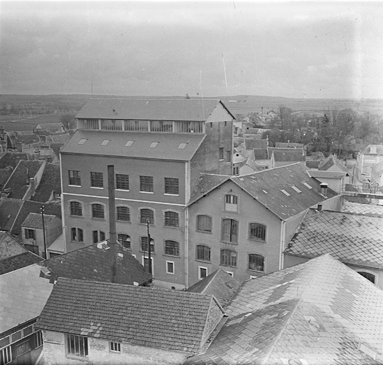 Vue rapprochée du bâtiment principal et de l'ancienne usine' (bâtiment A) depuis le haut de la tour d'Houdan. Au premier plan, la cheminée de la chaufferie.