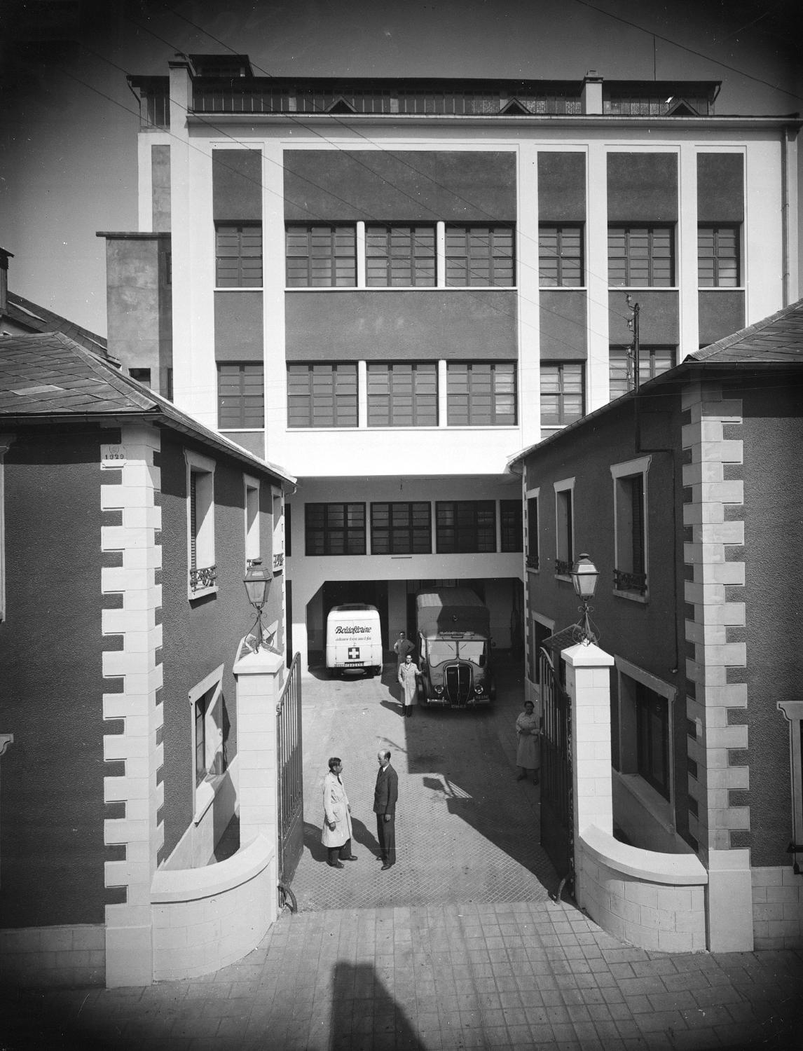 Vue de l'entrée des établissements Fouché, au fond le bâtiment principal, devant lequel est garée l'ambulance du tour de France.