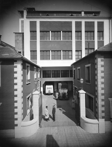 Vue de l'entrée des établissements Fouché, au fond le bâtiment principal, devant lequel est garée l'ambulance du tour de France.