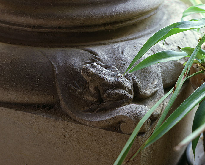 Vue du pavillon d'entrée, côté jardin : détail de la base de la colonne de droite ornée d'une grenouille.