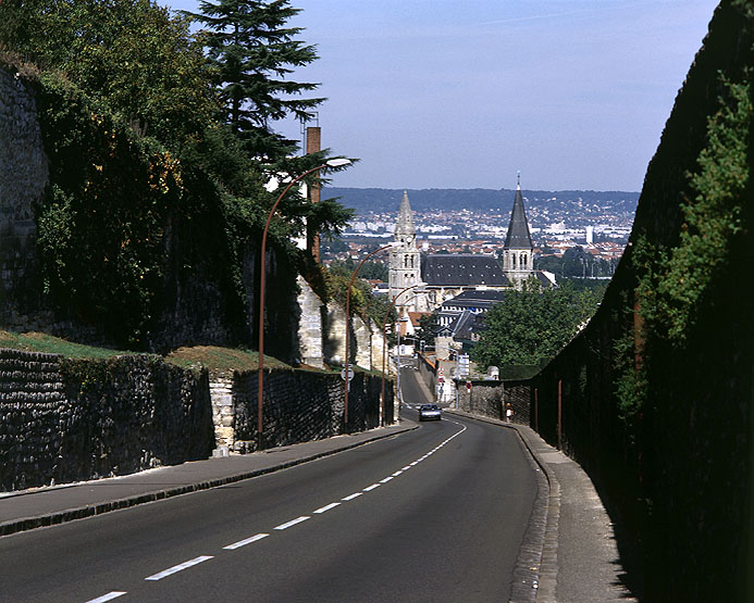 Vue de la rue de la Tournelle avec à droite le mur du cimetière, à gauche les vestiges de ceux du prieuré royal.