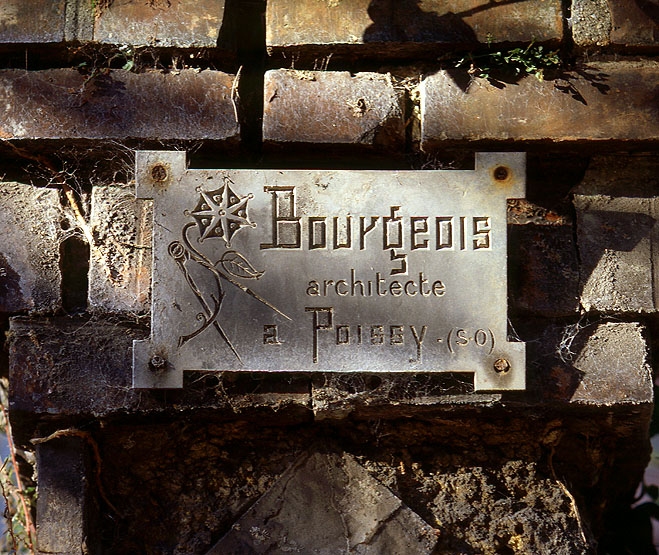 Détail de la plaque de l'architecte Théophile Bourgeois, apposée sur l'un des piliers de la clôture des jardins.