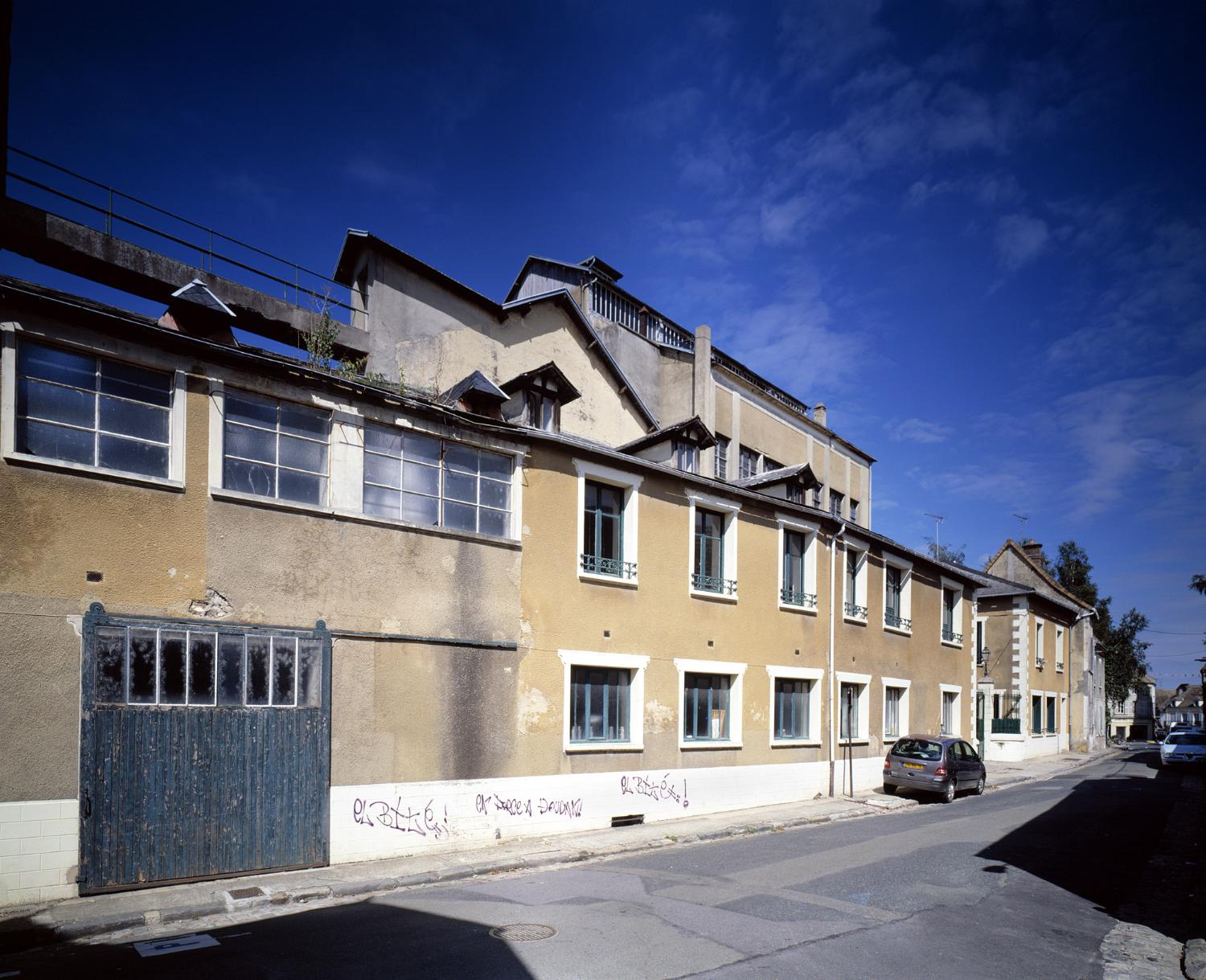 Vue d'ensemble des établissements Fouché depuis l'extrémité de la rue du Mont-Rôti. On aperçoit la passerelle extérieure conduisant du bâtiment A au réservoir.