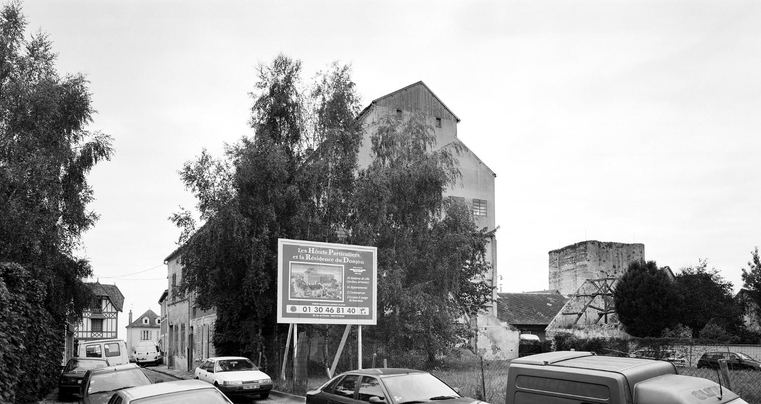 Vue du pignon du bâtiment principal depuis la rue du Mont-Rôti, à droite la tour d'Houdan. Au fond une maison "néo-normande" construite par l'entreprise pour y loger du personnel d'encadrement.
