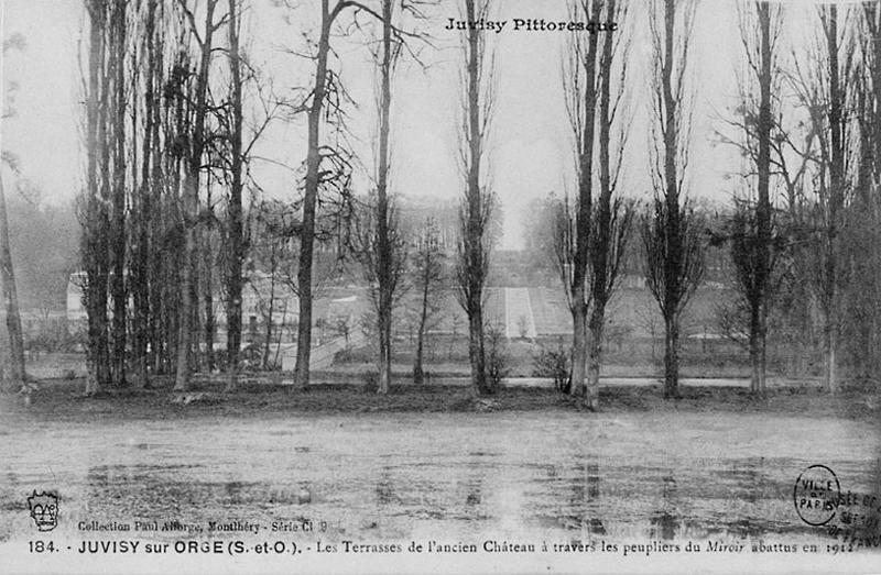 Les terrasses du parc vues à travers le rideau de peupliers bordant le miroir d'eau.