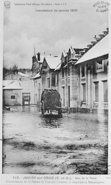 La rue de la Poste lors des inondations de 1910, avec, à droite, les bâtiments de la ferme de la Maladrerie.