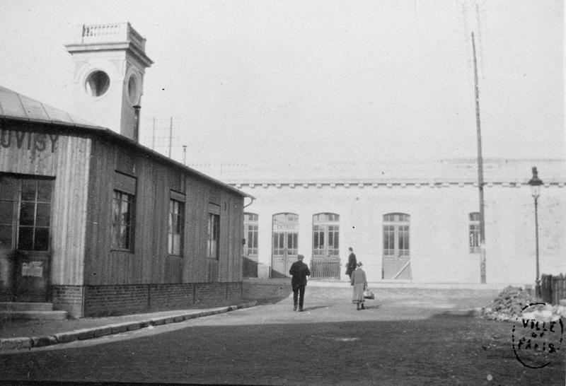 Gare de Juvisy-voyageurs : la gare intermédiaire provisoire en 1907, pendant le chantier de construction de la 2è gare, la gare actuelle, visible à l'arrière-plan.