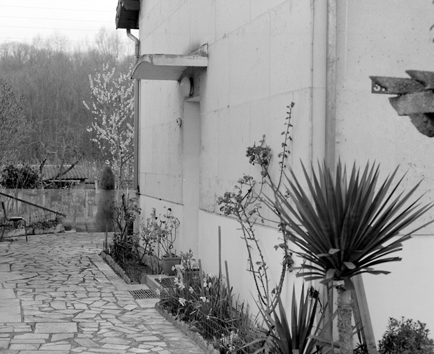 Détail de la marquise en béton armé au-dessus des portes d'entrée latérales d'un pavillon situé 37, avenue du 18 Avril.