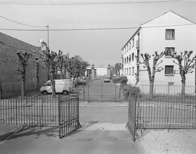 Ancienne allée d'honneur du château, photographiée de la Cité des Tilleuls en bordure de la rue Jean-Baptiste-Renoux : grilles et pilastres sur la rue Samuel-Desborde.