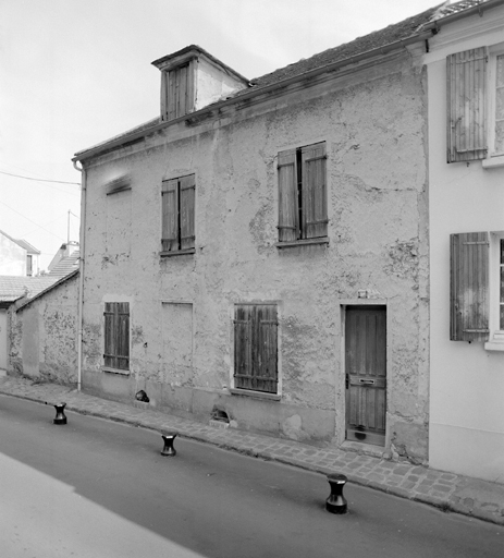Vue d'ensemble de la maison. La façade porte un enduit de plâtre gros.