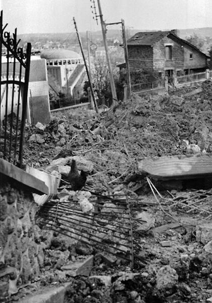 Vue des maisons ruinées et de l'église Notre-Dame endommagée par le bombardement de 1944.