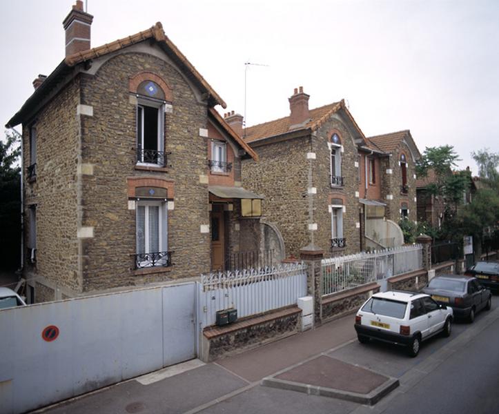 Vue perspective de l'ensemble d'un rang de maisons jumelées.