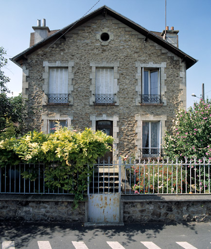 Vue d'ensemble de la maison ; les chaînes d'angle et l'encadrement des baies imitent la pierre de taille. Des joints rubannés et mouchetés entourent les moellons de meulière.