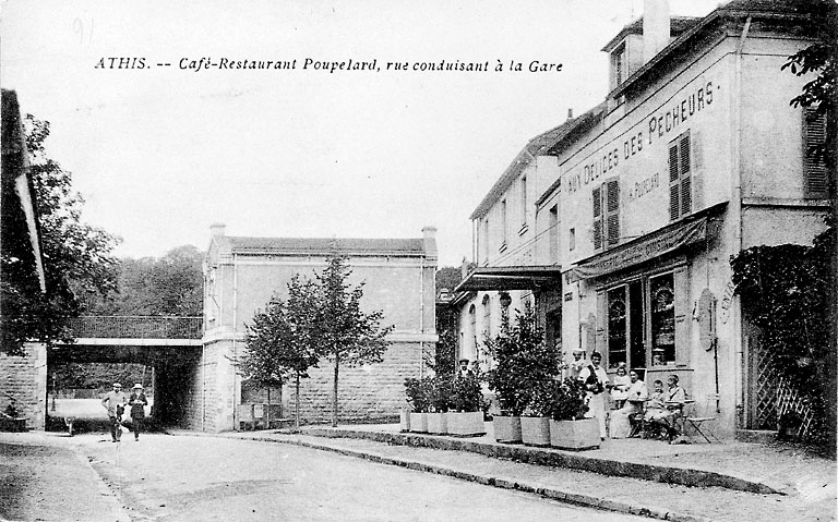 Vue du café restaurant 'Aux délices des pêcheurs' ; à l'arrière plan, côté Seine, l'abri pour voyageurs allant vers Juvisy, construit en même temps que la nouvelle gare et le passage inférieur, au moment du doublement des voies.