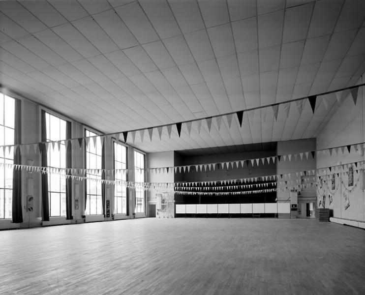 Vue d'ensemble de la salle des fêtes en direction de la scène.